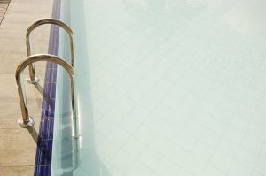 steps leading out of light blue swimming pool