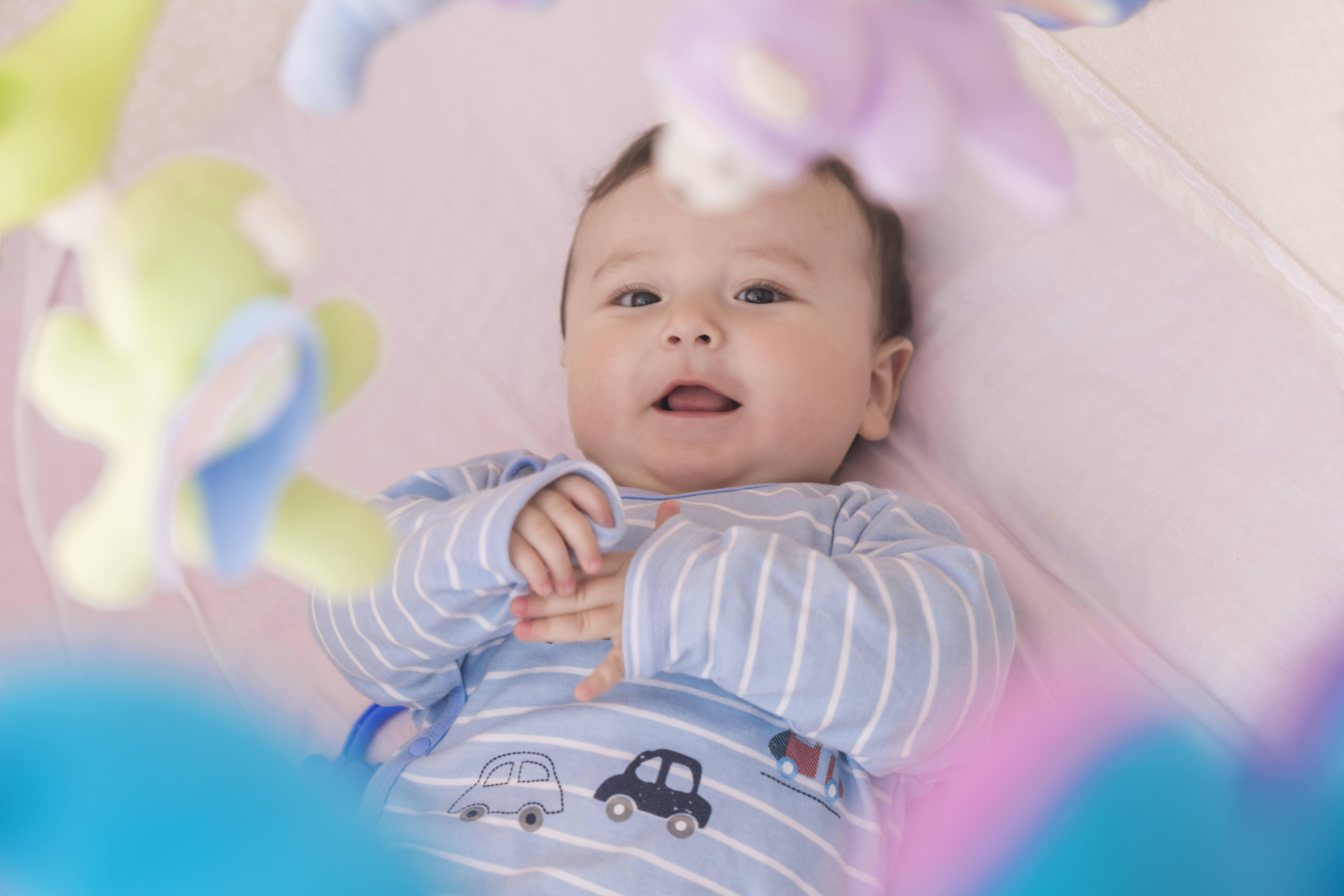 Happy baby lying in his crib smiling