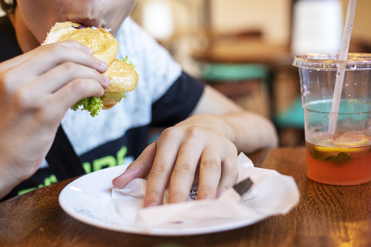 teenager eats a croissant with lemonade or fruit drink. Back to school, snack