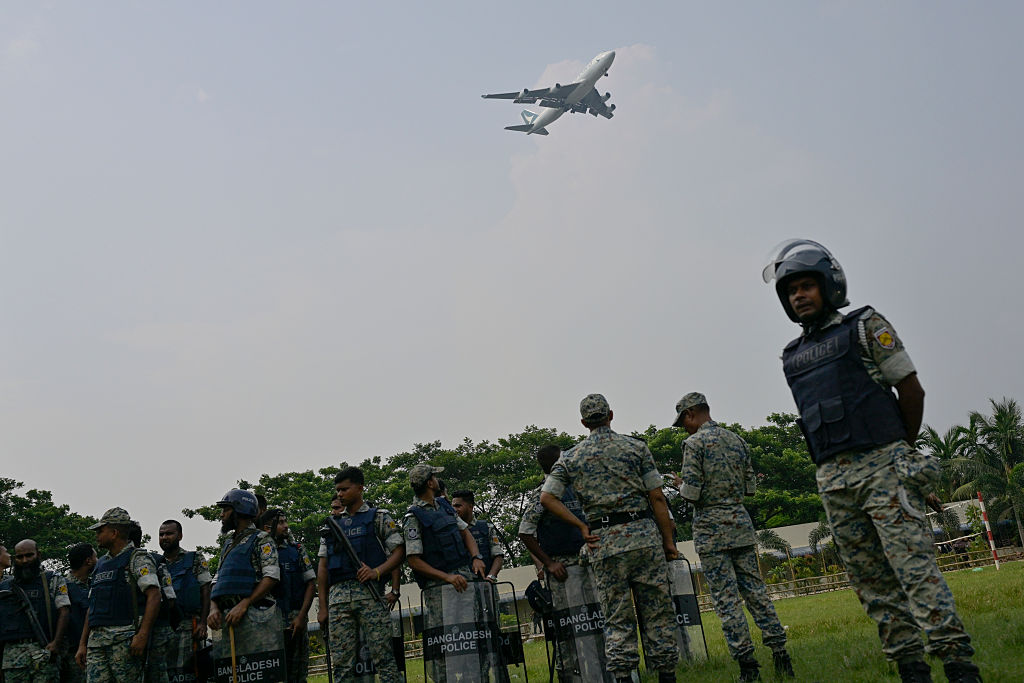 Military officers seen at the crash site, after a jet...