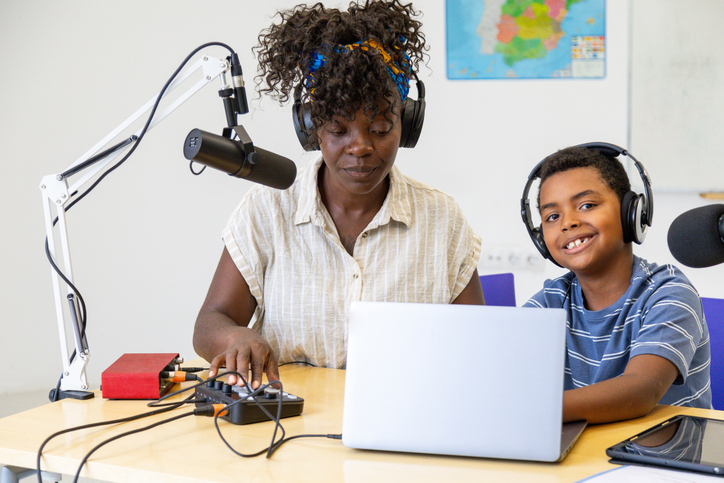 Teacher and student recording a podcast in a classroom