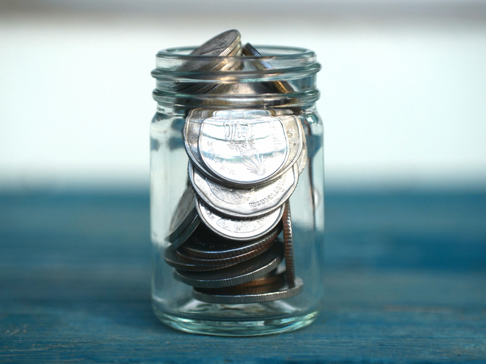 A lot of coins in a jar in the concept of saving money and finance.Selection focus.